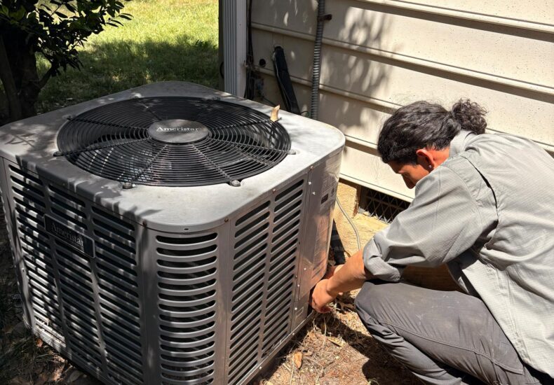 A technician completing AC repair service in the Mooresville, NC area.